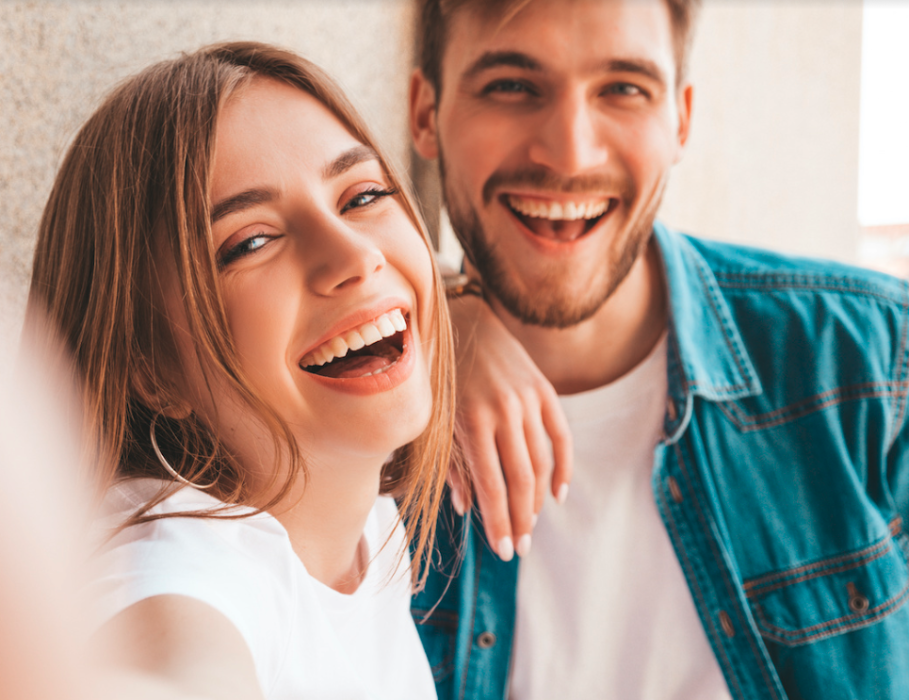 Younger white male and female smiling up against a wall, wilmington de