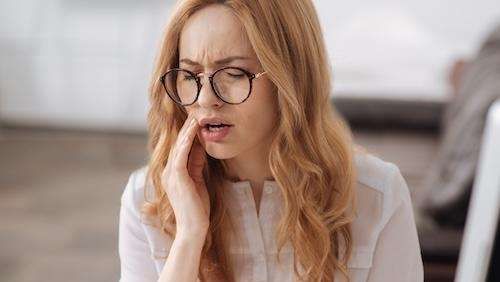 Red hair woman holding her jaw in pain, wilmington de