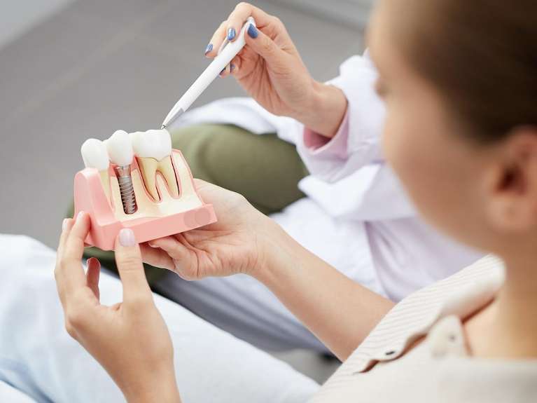Dentist showing a patient a diagram of dental implants, wilmington de