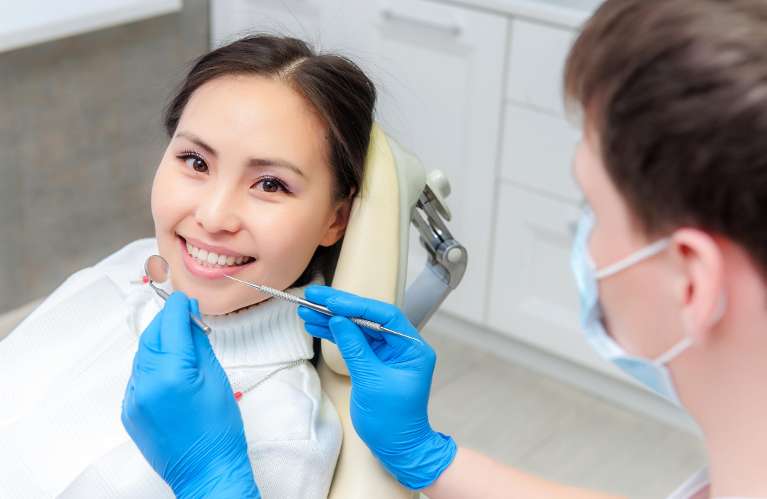 Asian woman smiling in dentist chair, wilmington de