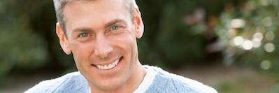 Older white man smiling after zirconia dental crowns, wilmington de